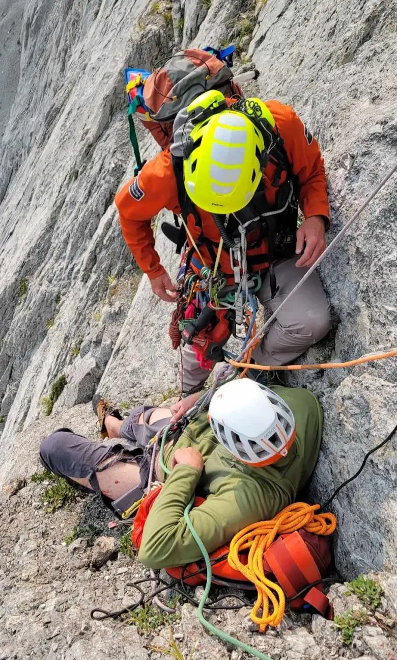 The Parks Canada rescue team members preparing me for descent. My pants were shredded in the fall. The bolts were placed as part of the rescue.